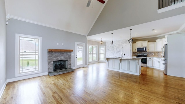 5120 Prickly Pine Pl, Murfreesboro, TN 37129 - unfurnished living room with ceiling fan, a fireplace, light wood-style floors, high vaulted ceiling, and crown molding