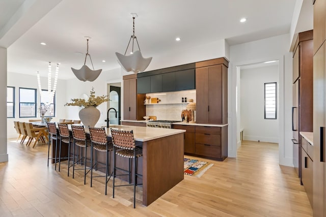 1209 Noelton Ave, Nashville, TN 37215 - kitchen featuring a breakfast bar, light wood-style flooring, light countertops, a kitchen island with sink, and recessed lighting
