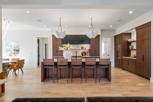 1209 Noelton Ave, Nashville, TN 37215 - kitchen featuring open shelves, light wood finished floors, modern cabinets, a breakfast bar area, and recessed lighting