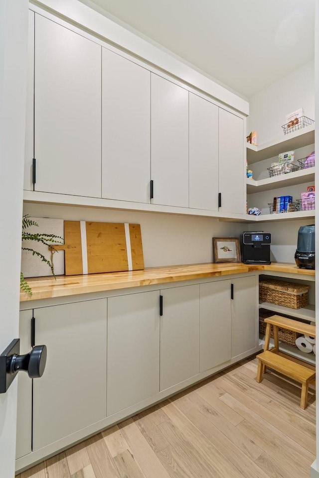 1209 Noelton Ave, Nashville, TN 37215 - kitchen featuring butcher block countertops, white cabinetry, built in study area, light wood-style floors, and open shelves
