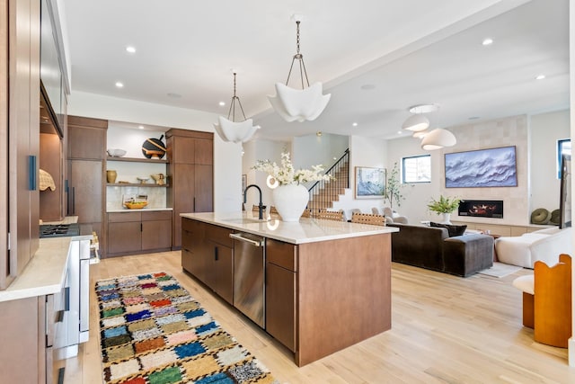 1209 Noelton Ave, Nashville, TN 37215 - kitchen featuring open shelves, stainless steel dishwasher, light wood-type flooring, a center island with sink, and light countertops
