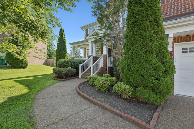 821 Alex Way, Mount Juliet, TN 37122 - view of exterior entry with brick siding, a garage, a yard, and covered porch