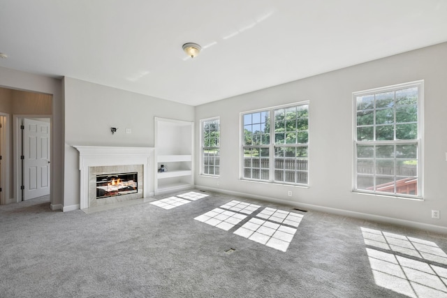 821 Alex Way, Mount Juliet, TN 37122 - unfurnished living room featuring a tiled fireplace, carpet floors, and built in features