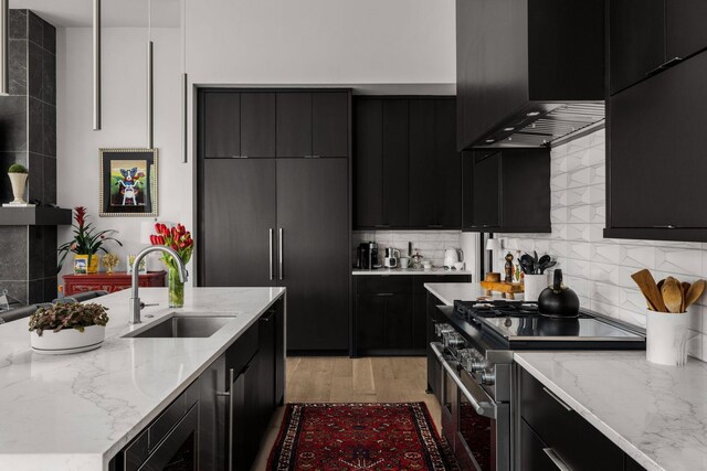 108 46th Ave N, Nashville, TN 37209 - kitchen featuring dark cabinetry, range with two ovens, range hood, and decorative backsplash