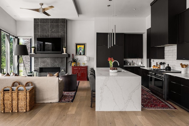 108 46th Ave N, Nashville, TN 37209 - kitchen with dark cabinetry, double oven range, modern cabinets, open floor plan, and a tiled fireplace