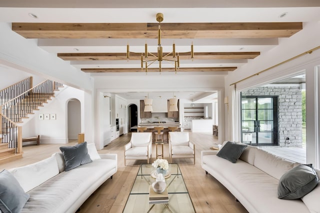1713 Reflection Ln, Brentwood, TN 37027 - living area featuring a chandelier, beam ceiling, stairs, light wood-style floors, and arched walkways