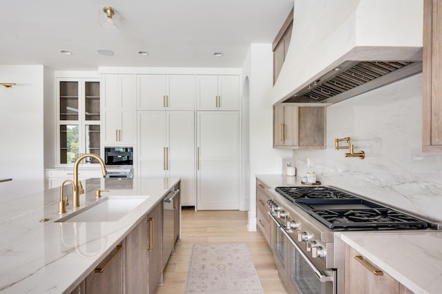 1713 Reflection Ln, Brentwood, TN 37027 - kitchen with custom range hood, stainless steel appliances, light stone counters, tasteful backsplash, and light wood finished floors