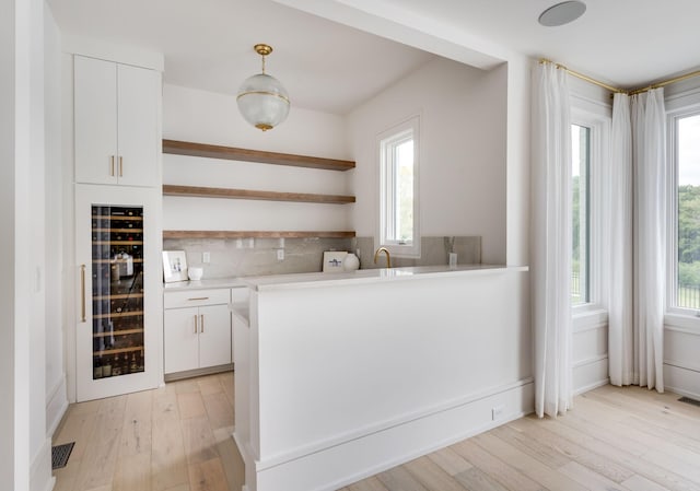 1713 Reflection Ln, Brentwood, TN 37027 - kitchen featuring wine cooler, open shelves, white cabinets, light wood-style floors, and light countertops