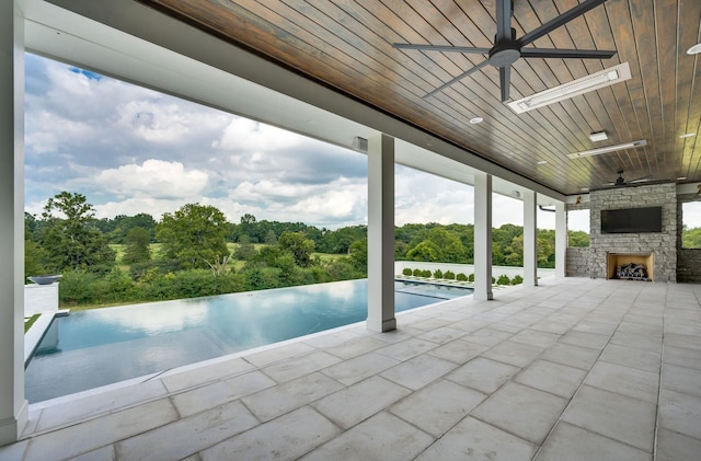 1713 Reflection Ln, Brentwood, TN 37027 - view of swimming pool featuring ceiling fan, an outdoor stone fireplace, a patio area, and an infinity pool