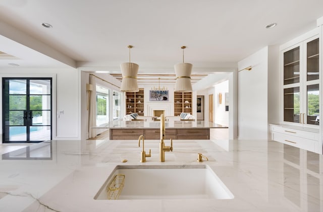 1713 Reflection Ln, Brentwood, TN 37027 - kitchen featuring open floor plan, french doors, light stone countertops, a fireplace, and a kitchen island