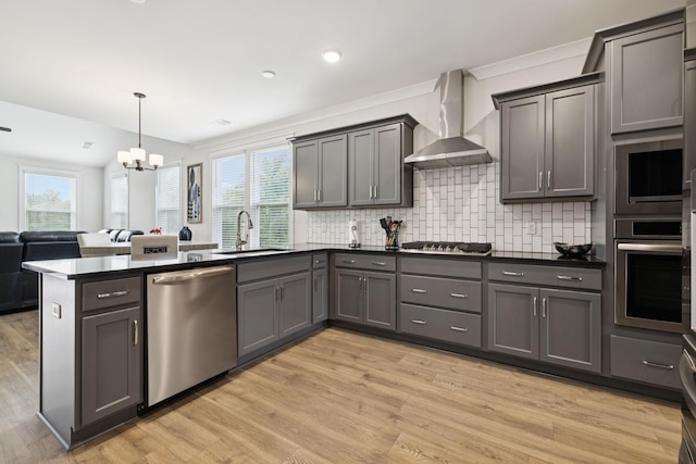 3737 Felipe Way, Murfreesboro, TN 37129 - kitchen featuring stainless steel appliances, wall chimney range hood, a peninsula, a chandelier, and light wood-style floors