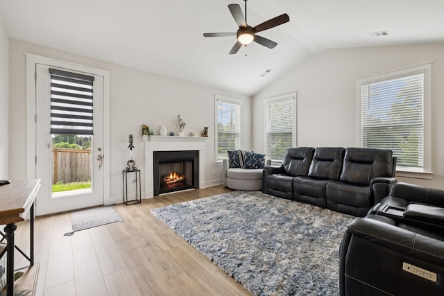 3737 Felipe Way, Murfreesboro, TN 37129 - living room featuring light wood-style flooring, ceiling fan, vaulted ceiling, and a warm lit fireplace
