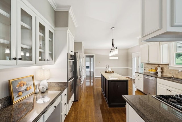 1524 Gordon Petty Dr, Brentwood, TN 37027 - kitchen featuring stainless steel appliances, ornamental molding, dark wood-style flooring, white cabinetry, and hanging light fixtures