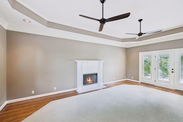 1524 Gordon Petty Dr, Brentwood, TN 37027 - unfurnished living room with wood finished floors, a tray ceiling, crown molding, a ceiling fan, and a glass covered fireplace