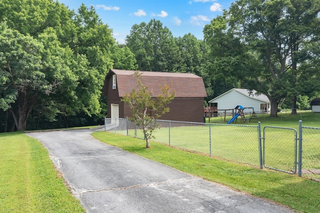 105 Plain View Dr, Estill Springs, TN 37330 - view of front of home with a gambrel roof, an outbuilding, driveway, a playground, and a shingled roof