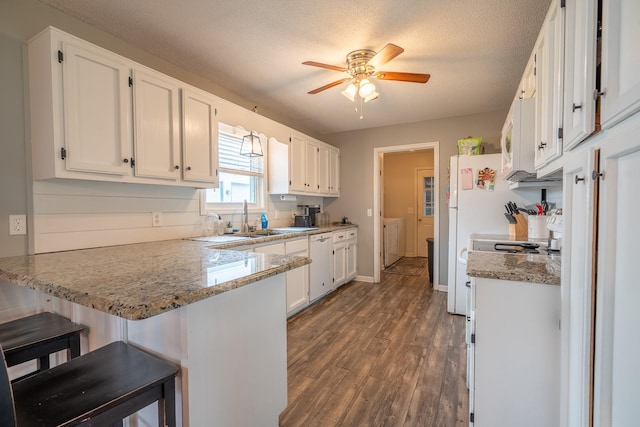 545 Kent St, Lawrenceburg, TN 38464 - kitchen with a peninsula, white appliances, white cabinetry, dark wood-type flooring, and a textured ceiling