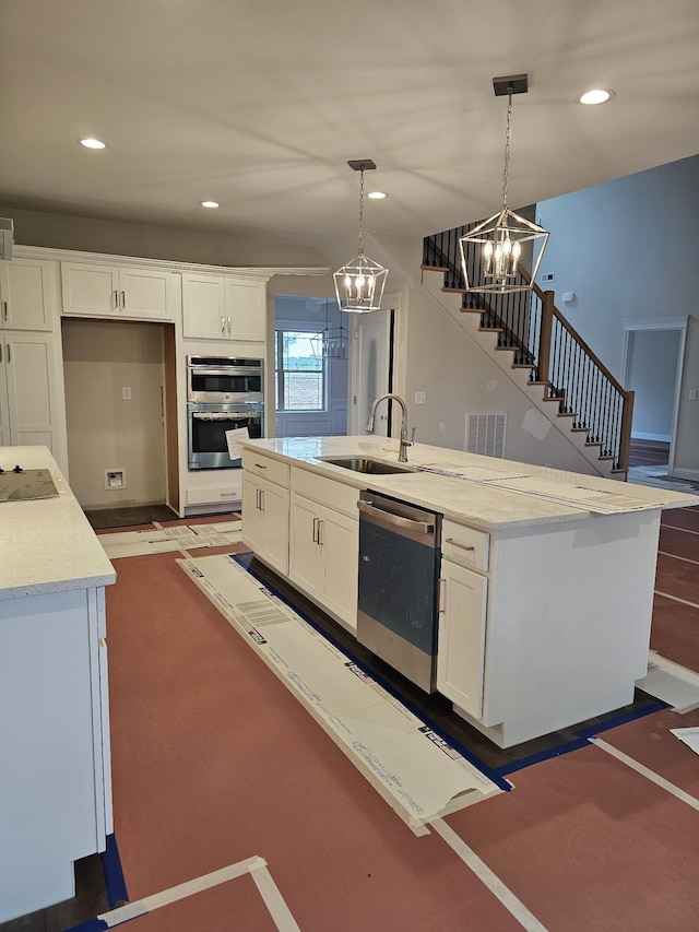 2895 Cooper Creek Rd, Woodlawn, TN 37191 - kitchen featuring appliances with stainless steel finishes, a chandelier, white cabinets, a center island with sink, and recessed lighting