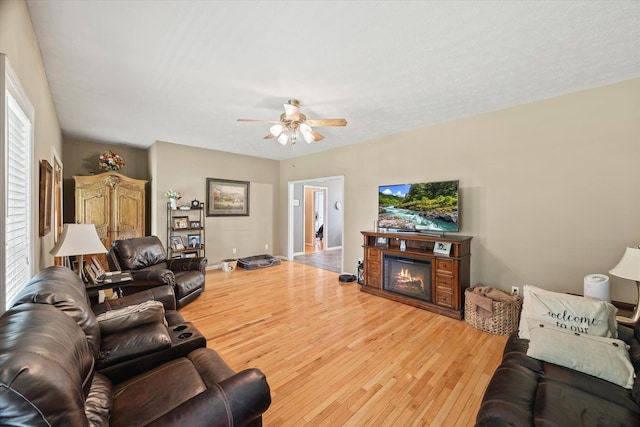 5546 Old Kentucky Rd, Byrdstown, TN 38549 - living area featuring light wood-style floors, ceiling fan, a glass covered fireplace, and plenty of natural light