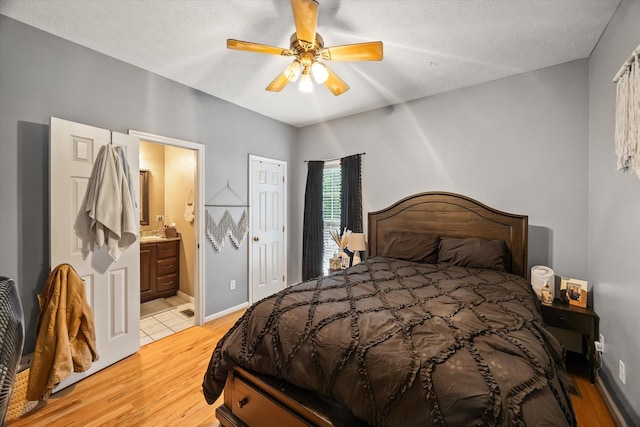 5546 Old Kentucky Rd, Byrdstown, TN 38549 - bedroom with light wood finished floors, ensuite bathroom, ceiling fan, and a textured ceiling