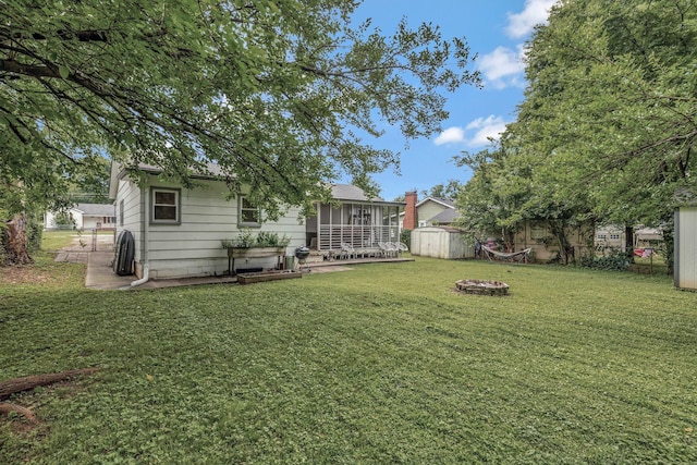 1519 Graybar Ln, Murfreesboro, TN 37129 - view of grassy yard featuring a storage unit, a fire pit, and a sunroom