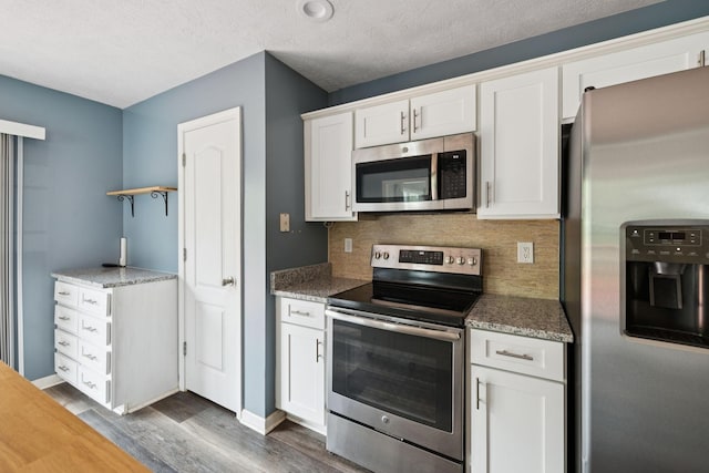 7607 Birdsong Ct, Fairview, TN 37062 - kitchen featuring stainless steel appliances, decorative backsplash, dark wood-style floors, white cabinets, and stone countertops