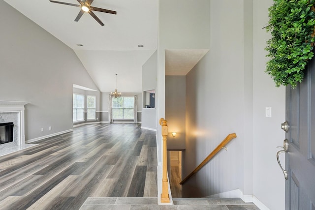 7607 Birdsong Ct, Fairview, TN 37062 - unfurnished living room with high vaulted ceiling, ceiling fan, a chandelier, wood finished floors, and a high end fireplace
