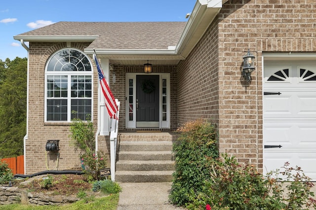 7607 Birdsong Ct, Fairview, TN 37062 - view of exterior entry featuring an attached garage, brick siding, and roof with shingles
