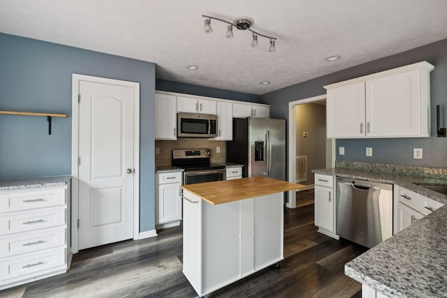 7607 Birdsong Ct, Fairview, TN 37062 - kitchen featuring appliances with stainless steel finishes, wood counters, white cabinetry, dark wood-style flooring, and recessed lighting