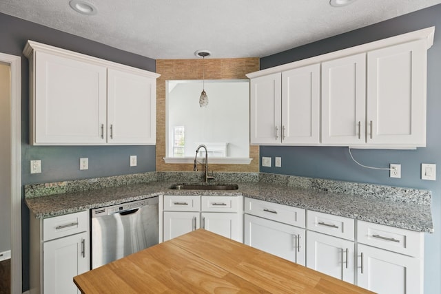 7607 Birdsong Ct, Fairview, TN 37062 - kitchen featuring stainless steel dishwasher, white cabinetry, pendant lighting, light stone countertops, and a textured ceiling