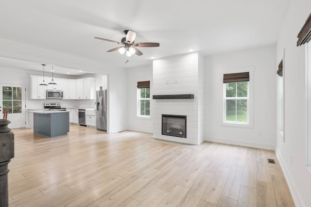 4486 Beards Chapel Rd, Springfield, TN 37172 - unfurnished living room with ceiling fan, plenty of natural light, recessed lighting, a large fireplace, and light wood-style floors