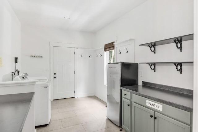 4486 Beards Chapel Rd, Springfield, TN 37172 - kitchen with open shelves, freestanding refrigerator, washer / dryer, dark countertops, and light tile patterned flooring