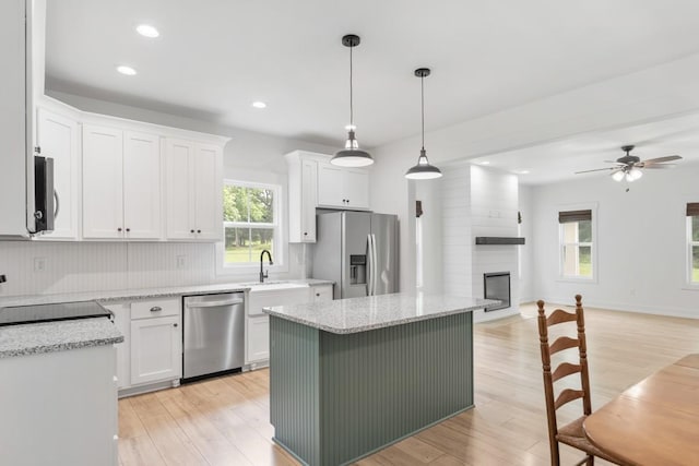 4486 Beards Chapel Rd, Springfield, TN 37172 - kitchen featuring appliances with stainless steel finishes, open floor plan, white cabinetry, a ceiling fan, and light wood-type flooring