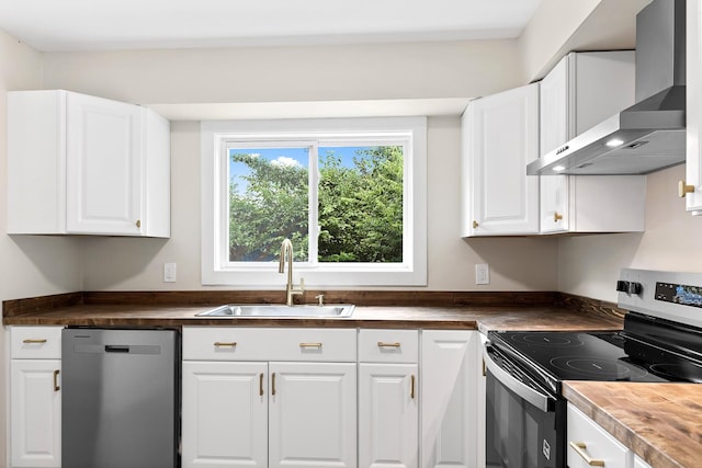 610 Maple Ln, Chattanooga, TN 37411 - kitchen featuring wall chimney range hood, appliances with stainless steel finishes, butcher block counters, and white cabinetry