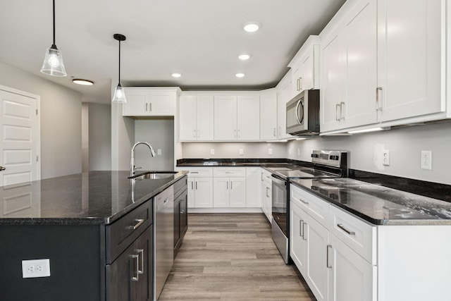 578 Oak Glen Dr, Smithville, TN 37166 - kitchen with stainless steel appliances, white cabinetry, light wood finished floors, recessed lighting, and decorative light fixtures