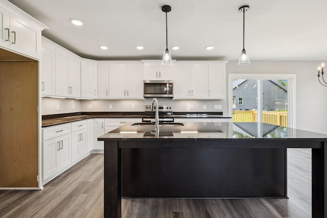 578 Oak Glen Dr, Smithville, TN 37166 - kitchen with stainless steel microwave, light wood-style flooring, white cabinetry, and recessed lighting
