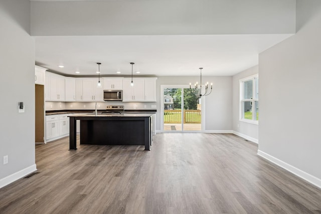578 Oak Glen Dr, Smithville, TN 37166 - kitchen with stainless steel microwave, dark countertops, range with electric stovetop, recessed lighting, and a chandelier