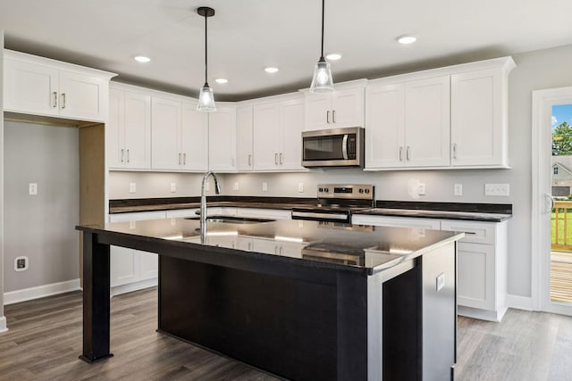578 Oak Glen Dr, Smithville, TN 37166 - kitchen with stainless steel appliances, wood finished floors, white cabinetry, decorative light fixtures, and recessed lighting