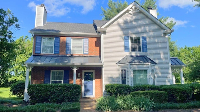 1270 Carriage Park Dr, Franklin, TN 37064 - view of front of house with a chimney, a standing seam roof, brick siding, and a metal roof