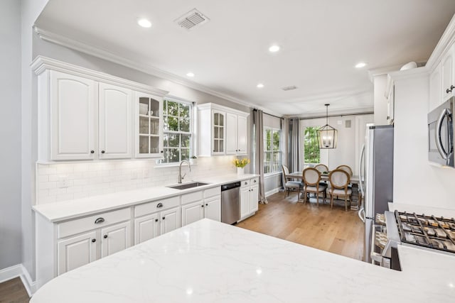 311 Wandering Cir, Franklin, TN 37067 - kitchen with appliances with stainless steel finishes, white cabinets, light wood finished floors, glass insert cabinets, and tasteful backsplash