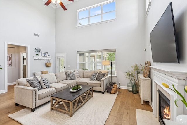 311 Wandering Cir, Franklin, TN 37067 - living room with a ceiling fan, light wood-type flooring, a high ceiling, a high end fireplace, and plenty of natural light