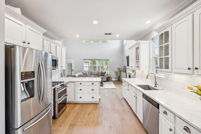 311 Wandering Cir, Franklin, TN 37067 - kitchen with appliances with stainless steel finishes, open floor plan, white cabinets, glass insert cabinets, and recessed lighting