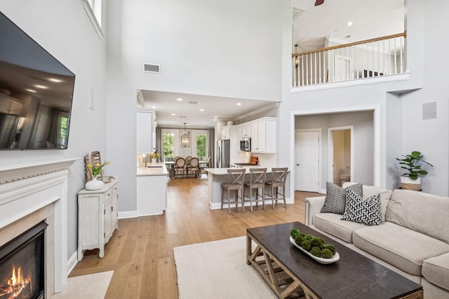 311 Wandering Cir, Franklin, TN 37067 - living room featuring a high ceiling, a premium fireplace, light wood-style flooring, and recessed lighting