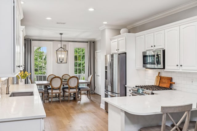 311 Wandering Cir, Franklin, TN 37067 - kitchen featuring appliances with stainless steel finishes, white cabinetry, crown molding, tasteful backsplash, and recessed lighting