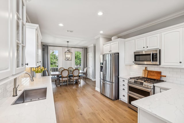 311 Wandering Cir, Franklin, TN 37067 - kitchen featuring stainless steel appliances, white cabinets, ornamental molding, glass insert cabinets, and recessed lighting