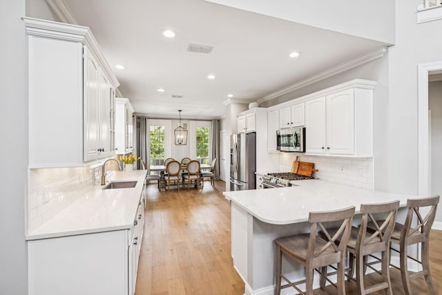311 Wandering Cir, Franklin, TN 37067 - kitchen featuring appliances with stainless steel finishes, crown molding, white cabinetry, recessed lighting, and a peninsula