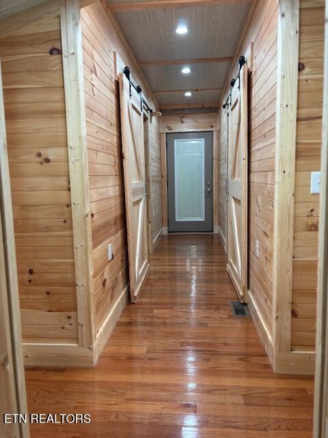 337 Bellview Rd, Pikeville, TN 37367 - hallway featuring a barn door, wooden walls, hardwood / wood-style floors, recessed lighting, and wooden ceiling