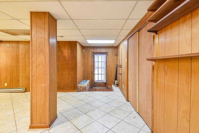1204 Rolling Fields Dr, Columbia, TN 38401 - below grade area featuring a baseboard radiator, a paneled ceiling, light tile patterned floors, and wooden walls