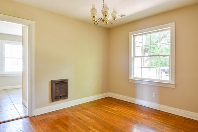 1204 Rolling Fields Dr, Columbia, TN 38401 - empty room featuring heating unit, a chandelier, and light wood-type flooring