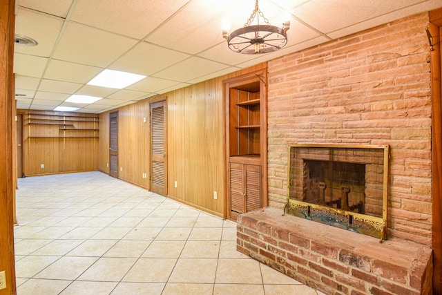1204 Rolling Fields Dr, Columbia, TN 38401 - unfurnished living room with a paneled ceiling, wood walls, built in shelves, a fireplace, and tile patterned floors