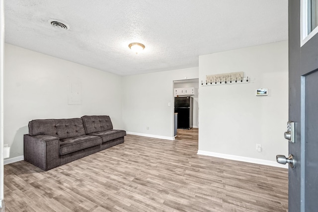408 Eddy St, Oak Grove, KY 42262 - unfurnished living room with wood finished floors and a textured ceiling
